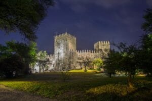 a castle lit up at night with trees in the foreground